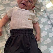 Marley joined the competition — help win amazing prizes! baby, smile, infant, clothing, shorts, shirt, socks, dinosaur, pattern, clouds, mat, light, indoor, cute, happy, person, child, laying, soft_light, casual_wear