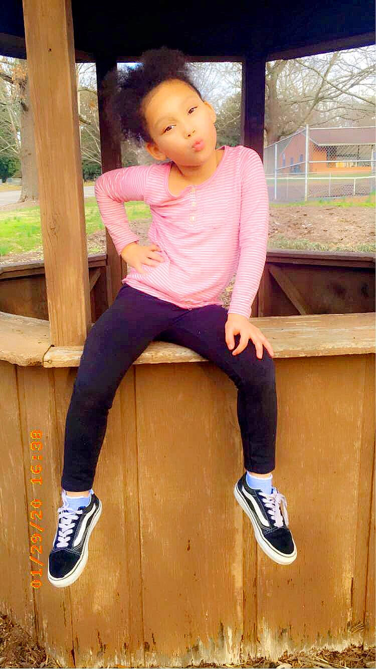 Zavriana is registered to the contest to win money with this photo: footwear, grass, hair, happy, head, human_leg, knee, leisure, outdoor_shoe, person, pink, plant, shoe, sleeve, snapshot, sneakers, street_fashion, t_shirt, thigh, toddler