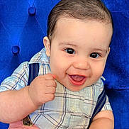 Victor joined the competition — help win amazing prizes! baby, child, smiling, happy, plaid_shirt, pink_pants, suspenders, blue_chair, cushioned_chair, hand_holding, indoor, portrait, cute, infant, person, face, eyes, mouth, skin, clothing