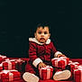 toddler, child, red_clothing, gift_box, pink_ribbon, holiday, christmas, present, sitting, curious, indoor, portrait, baby, white_shoes, red_floor, dark_background, cozy, festive, cute, small_child