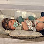 Stetson is registered to the contest to win money with this photo: baby, bassinet, pacifier, camo_hat, mittens, infant, sleepwear, cushion, soft_lighting, indoors, baby_clothes, resting, newborn, crib, blanket, comfort, child, cute, face, lying_down