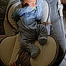 baby, pacifier, blue_onesie, infant, baby_rocker, cushion, hand, sleeping, indoor, soft_lighting, newborn, baby_clothes, baby_sleeping, baby_accessory, baby_bed, child, person, resting, cute, comfort