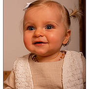 Jade a rejoint le concours — aidez-le/la à gagner de superbes lots ! baby_necklace, beige_clothing, blonde_hair, blue_eyes, child, closeup, cute, face, happy, headshot, indoor, infant, knit_texture, person, ponytail, portrait, smile, soft_lighting, toddler, warm_tones