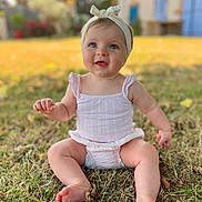 Jade participe au concours pour gagner de l'argent avec cette photo : baby, child, grass, outdoor, smiling, headband, blue_eyes, summer_clothing, barefoot, nature, sunlight, cute, portrait, sitting, infant, happy, skin, person, daylight, background_blur