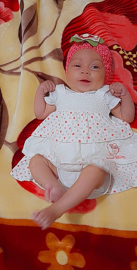 Fatima participe au concours pour gagner de l'argent avec cette photo : baby, baby_toddler_clothing, cheek, clothing, comfort, day_dress, dress, face, happy, headgear, headwear, leg, mouth, one_piece_garment, pattern, person, pink, skin, sleeve, smile