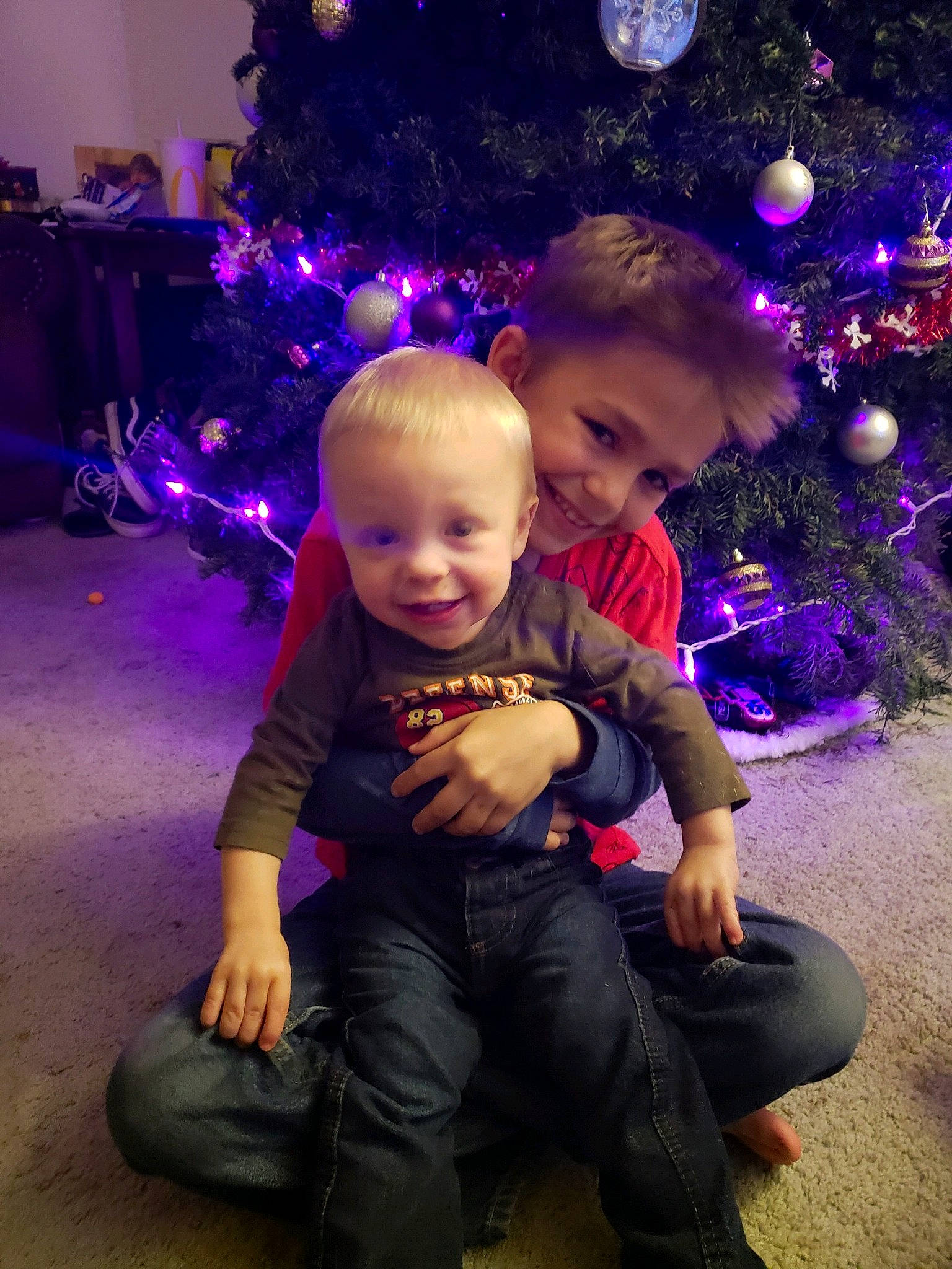 Ellis James joined the competition — help win amazing prizes! child, christmas, christmas_decoration, christmas_eve, christmas_lights, christmas_ornament, christmas_tree, event, fir, fun, happy, holiday, interior_design, joy, person, photography, plant, purple, sitting, smile