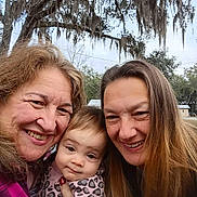 Amara joined the competition — help win amazing prizes! background, casual, child, clothing, daylight, face, family, grass, hair, happy, nature, outdoor, person, portrait, skin, smile, toddler, tree, tree_branch, woman