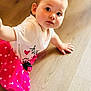 baby, child, clothing, crawling, curious, cute, flooring, heart, indoor, person, pink_skirt, polka_dots, ponytail, portrait, small_hands, toddler, white_shirt, wide_eyes, wooden_floor, young_child