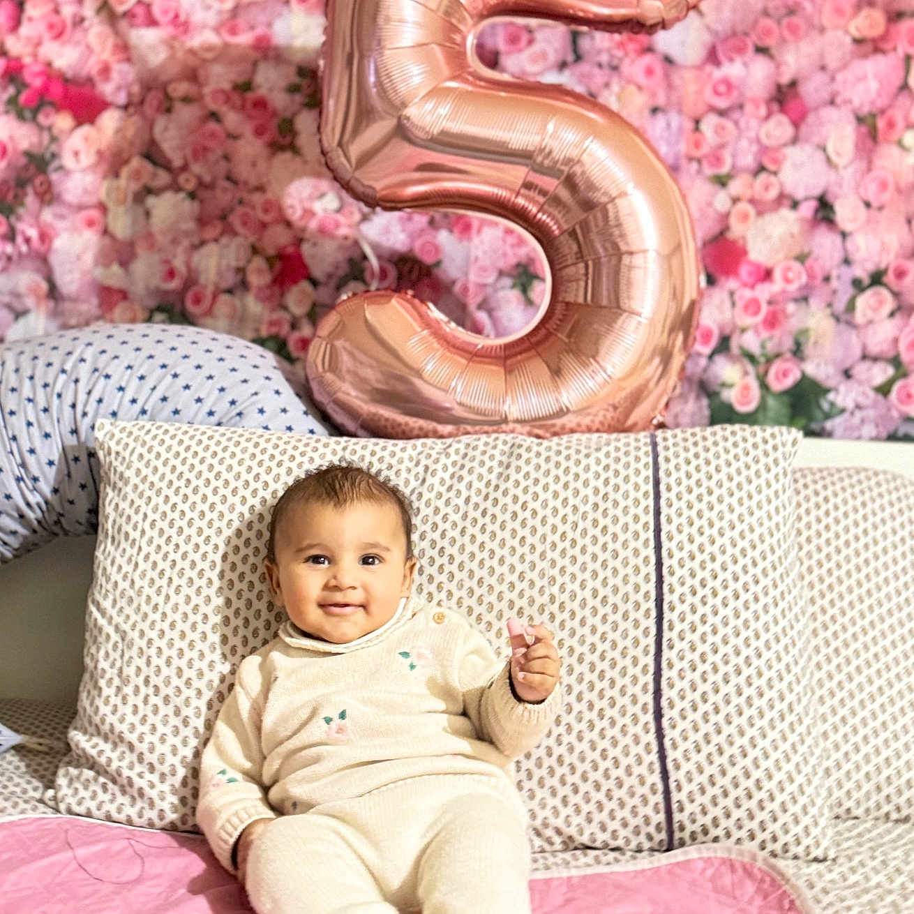 Arzoi is registered to the contest to win money with this photo: baby, balloon, blanket, celebration, child, couch, cozy, decor, flower_wall, happy, home, indoor, infant, knitwear, number_5, pattern, pink, portrait, relaxed, smile