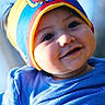 Logan joined the competition — help win amazing prizes! baby, child, smiling, headband, colorful, blue_shirt, face, portrait, cute, happy, infant, hand, closeup, indoors, natural_light, person, skin, eyebrows, eyes, expression