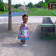 Natalie is registered to the contest to win money with this photo: child, toddler, dress, playground, outdoor, sandy_ground, bench, tree, grass, greenery, park, shoes, person, daylight, playing, recreation, curious, young_child, nature, fun