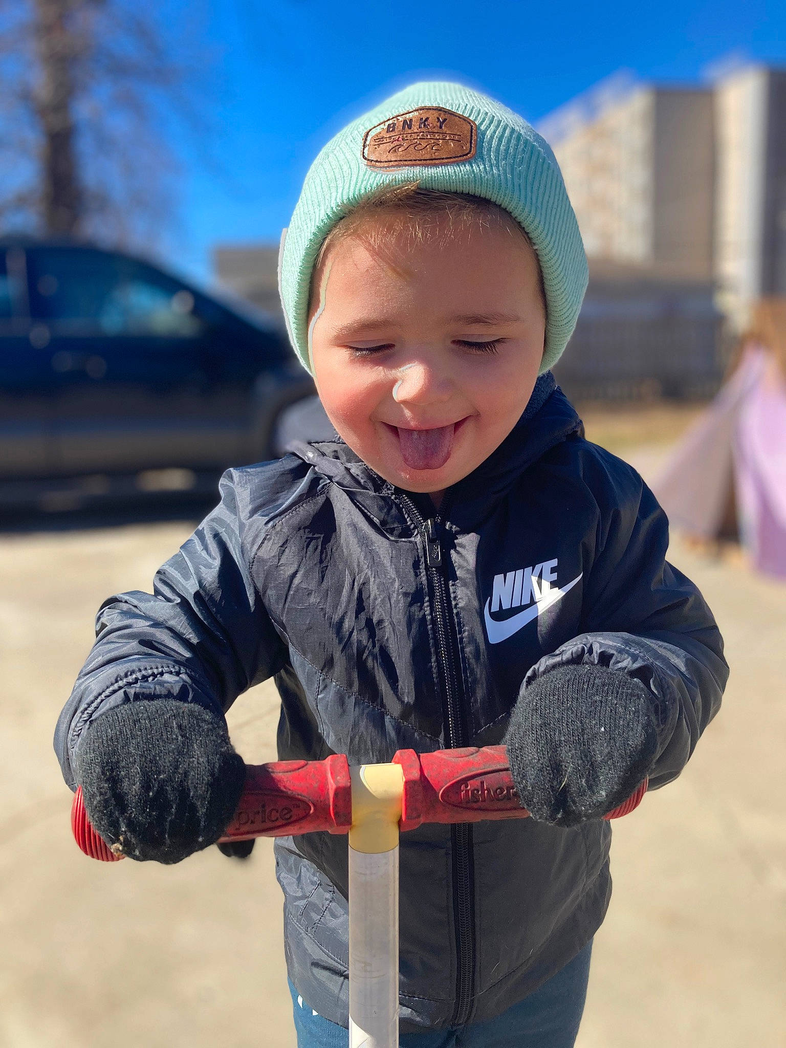 Zane is registered to the contest to win money with this photo: baseball_cap, blue, cap, car, child, electric_blue, eye, fun, glove, grass, happy, headgear, jacket, joy, person, recreation, sky, smile, standing, tire
