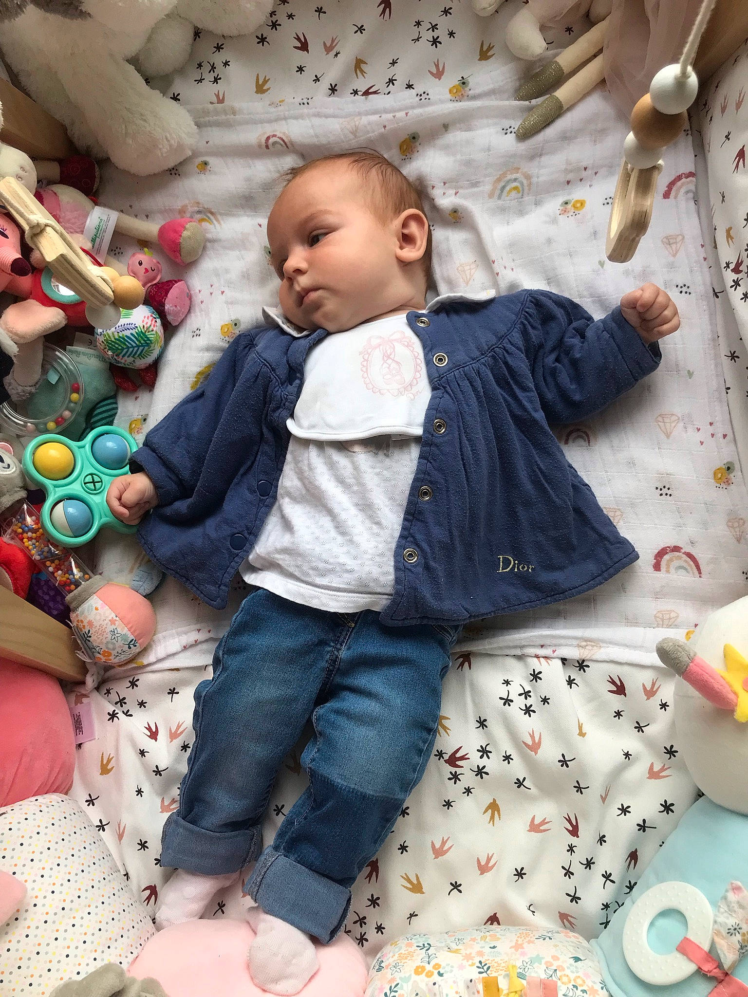 Romy participe au concours pour gagner de l'argent avec cette photo : baby, baby_toddler_clothing, cheek, child, comfort, event, eye, fun, happy, head, linens, pattern, person, play, sitting, skin, textile, toddler, white, wood