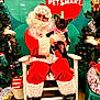 Muney is registered to the contest to win money with this photo: santa_claus, dog, black_dog, pink_sweater, christmas, holiday, petsmart, chair, decorations, plush_toys, christmas_tree, festive, glasses, white_beard, red_suit, indoor, smiling, person, pet, holiday_spirit