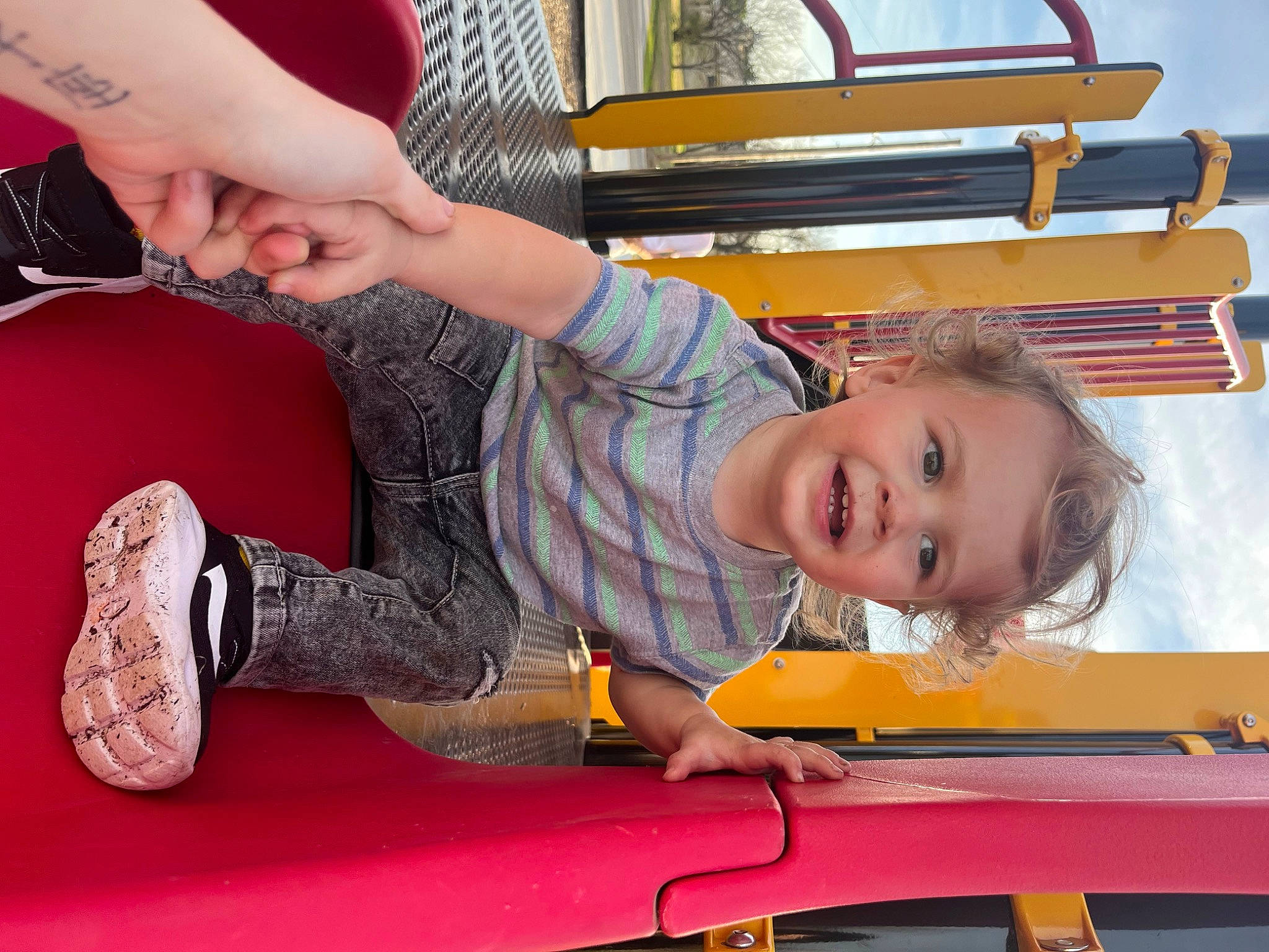 Sylas is registered to the contest to win money with this photo: carmine, child, elbow, flooring, fun, gesture, happy, human_leg, joy, leisure, nail, orange, person, recreation, room, sitting, smile, table, thigh, toddler