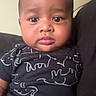 Sekani is registered to the contest to win money with this photo: animal_print, baby, black_clothing, child, chubby_cheeks, cute, expression, eyes, face, head, indoors, infant, looking_at_camera, onesie, person, portrait, sitting, skin, young_baby, young_child