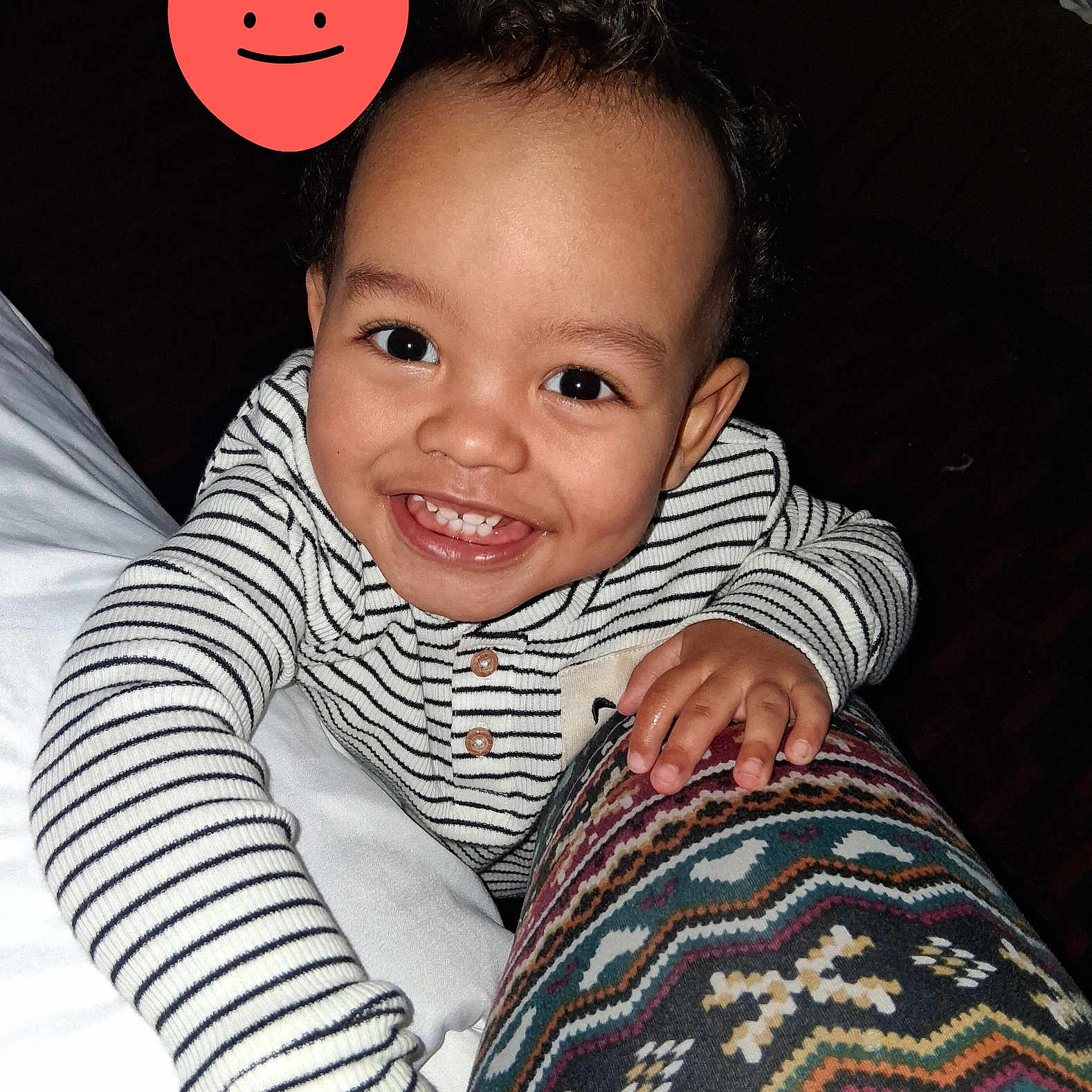 Andre is registered to the contest to win money with this photo: baby, cheerful, child, clothing, curly_hair, cute, eyes, face, hand, happy, indoor, joyful, patterned_fabric, person, portrait, skin, smiling, striped_clothing, toddler, young_child