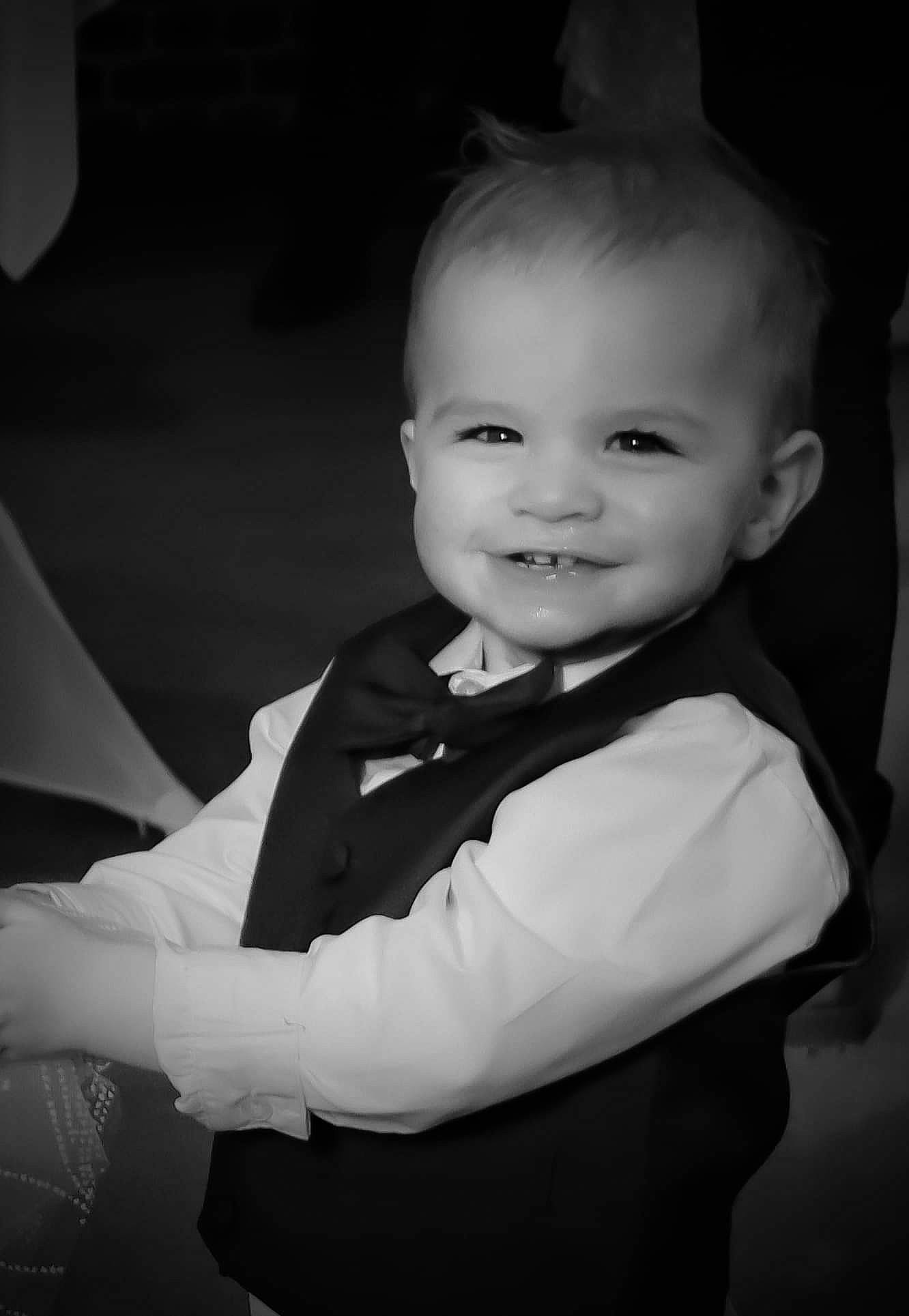Chris participe au concours pour gagner de l'argent avec cette photo : baby, baby_toddler_clothing, black_and_white, child, collar, event, flash_photography, formal_wear, fun, gesture, happy, joy, monochrome, monochrome_photography, person, sleeve, smile, standing, style, suit