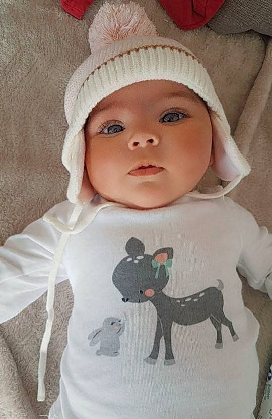 Yamina a rejoint le concours — aidez-le/la à gagner de superbes lots ! baby, baby_toddler_clothing, cap, cheek, cool, eye, eyelash, head, headgear, headwear, human_body, lip, mammal, outerwear, person, pink, skin, sleeve, t_shirt, textile