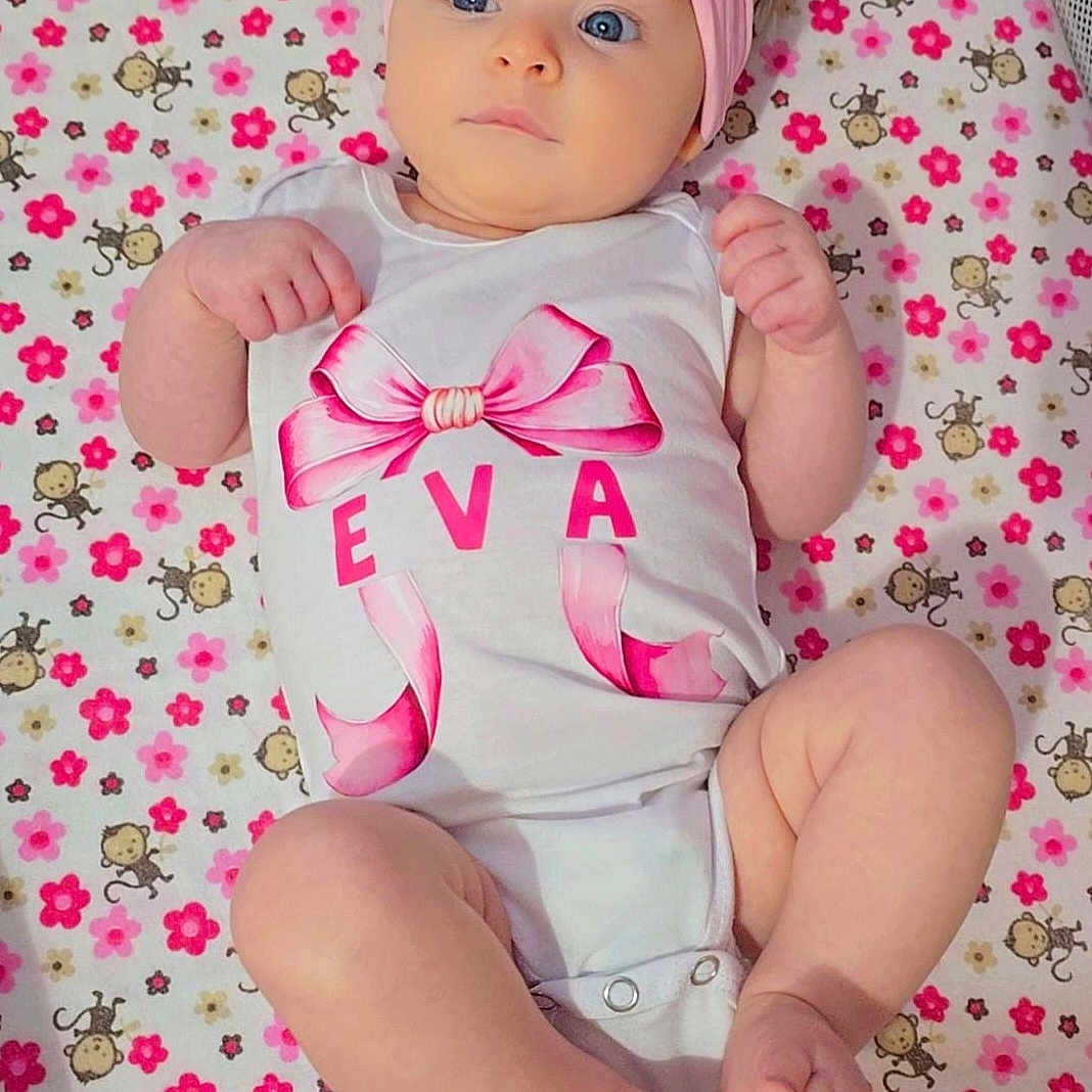 Eva joined the competition — help win amazing prizes! adorable, baby, baby_clothing, blanket, blue_eyes, child, cute, flower_pattern, headband, indoors, infant, lying_down, monkey_pattern, onesie, pink_bow, portrait, small_feet, small_hands, soft_lighting, toddler