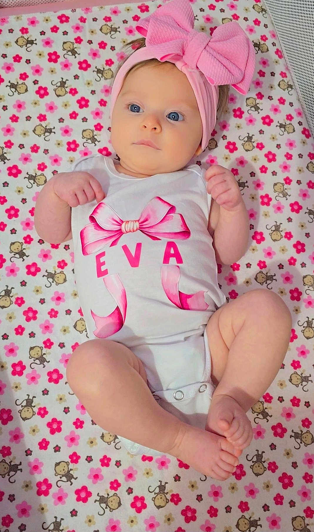 Eva joined the competition — help win amazing prizes! baby, infant, child, onesie, headband, pink_bow, blanket, monkey_pattern, flower_pattern, blue_eyes, cute, lying_down, small_hands, small_feet, indoors, soft_lighting, portrait, baby_clothing, adorable, toddler