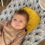 Pablo participe au concours pour gagner de l'argent avec cette photo : baby, baby_seat, child, cute, face, furniture, happy, head, indoors, infant, patterned_baby_seat, person, portrait, sitting, skin, smile, striped_clothing, wooden_floor, yellow_cushion, young_child