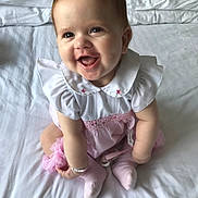 Layla-Leigh joined the competition — help win amazing prizes! baby, infant, smile, sitting, white_bed, pink_outfit, cute, happy, child, indoors, clothing, sock, bracelet, face, portrait, young_child, toddler, soft_light, bedroom, cute_expression