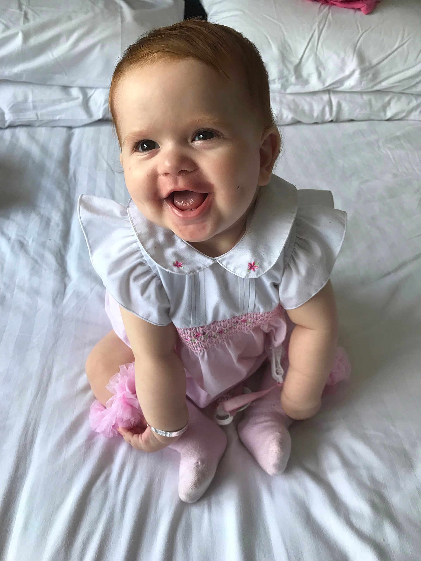 Layla-Leigh joined the competition — help win amazing prizes! baby, infant, smile, sitting, white_bed, pink_outfit, cute, happy, child, indoors, clothing, sock, bracelet, face, portrait, young_child, toddler, soft_light, bedroom, cute_expression