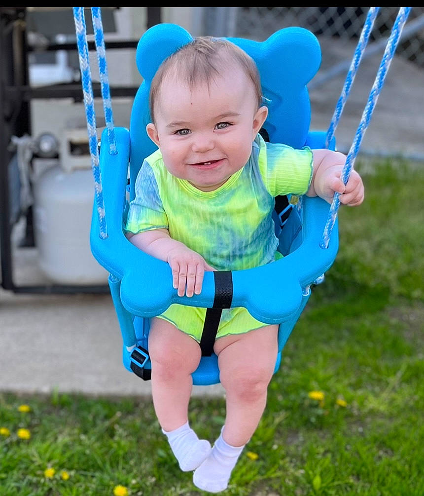 Quinn is registered to the contest to win money with this photo: azure, baby, baby_toddler_clothing, blue, electric_blue, facial_expression, grass, happy, joy, leisure, people_in_nature, person, photograph, playground, recreation, smile, snapshot, summer, swing, t_shirt