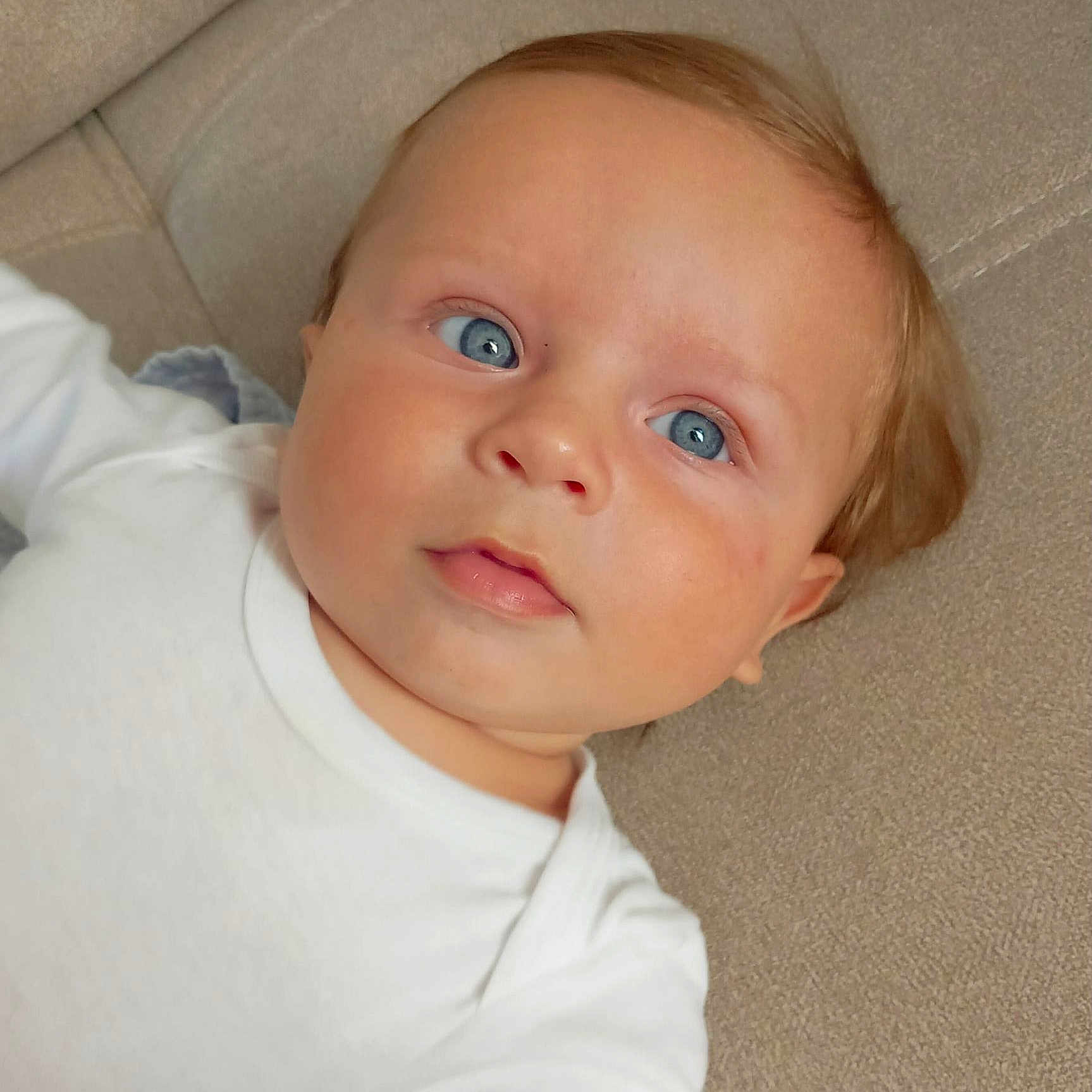 Mahé a rejoint le concours — aidez-le/la à gagner de superbes lots ! baby, blue_eyes, child, closeup, couch, cushion, cute, expression, face, head, indoors, infant, laying, peaceful, person, portrait, skin, soft_texture, white_clothing, young