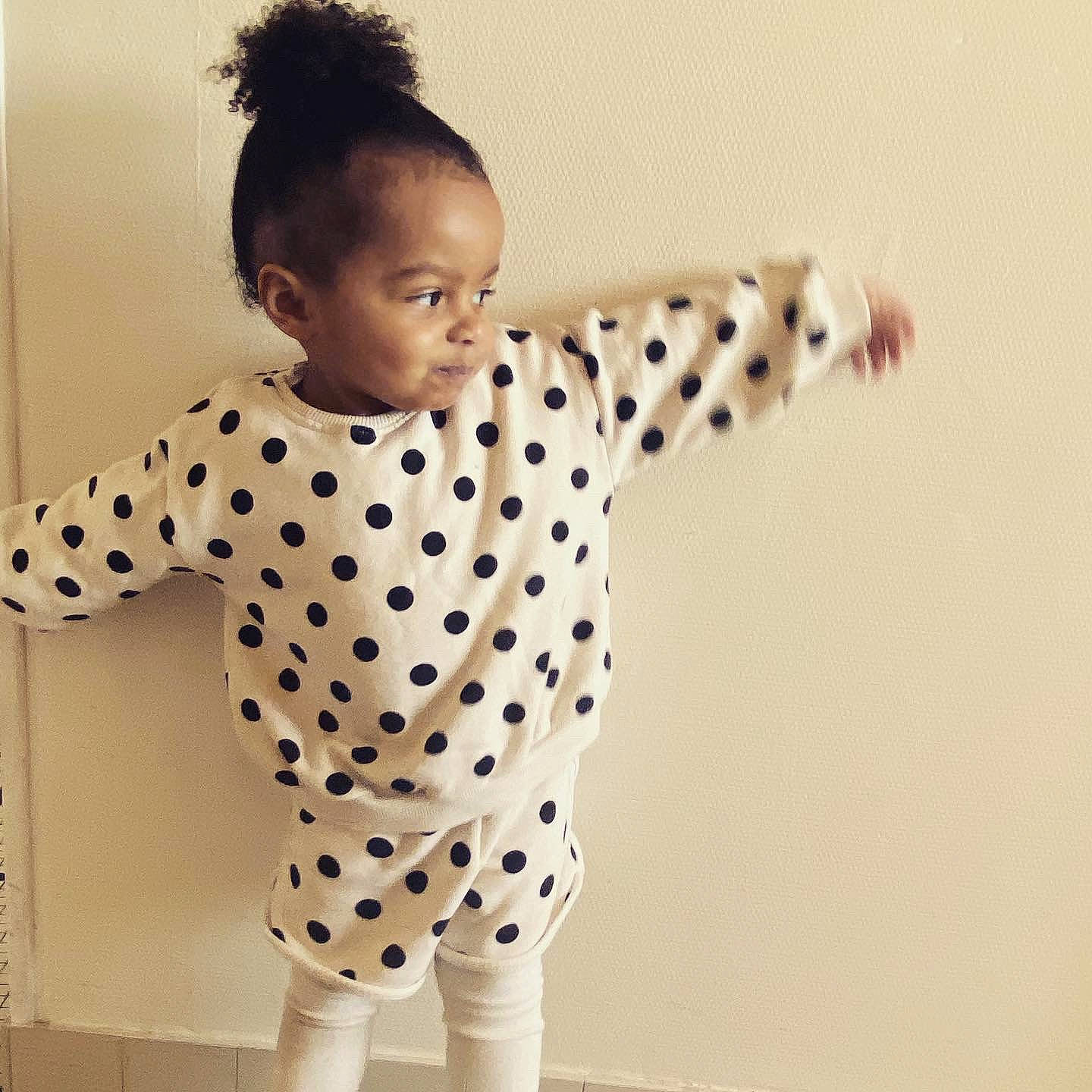 Romane participe au concours pour gagner de l'argent avec cette photo : arm, dress_shirt, elbow, eye, fashion_design, finger, fun, gesture, hair, hairstyle, happy, human_body, neck, pattern, person, shoulder, sleeve, standing, t_shirt, toddler