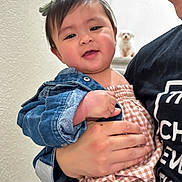 Naomi is registered to the contest to win money with this photo: baby, child, adult, denim_jacket, gingham_outfit, stairs, dog, pet, indoor, person, smile, holding, face, hand, hair_bow, cute, family, love, portrait, happy