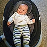 Gregory is registered to the contest to win money with this photo: baby, infant, child, smiling, tongue_out, portrait, indoor, bouncer, baby_seat, pacifier, striped_clothing, long_sleeves, carpet, home, lying_down, happy, face, eyes, playful, photography