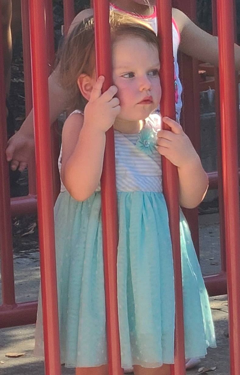 Iris is registered to the contest to win money with this photo: baby, baby_toddler_clothing, child, day_dress, face, finger, fun, gesture, happy, joint, leisure, magenta, person, pink, shoulder, skin, sleeve, standing, thumb, toddler