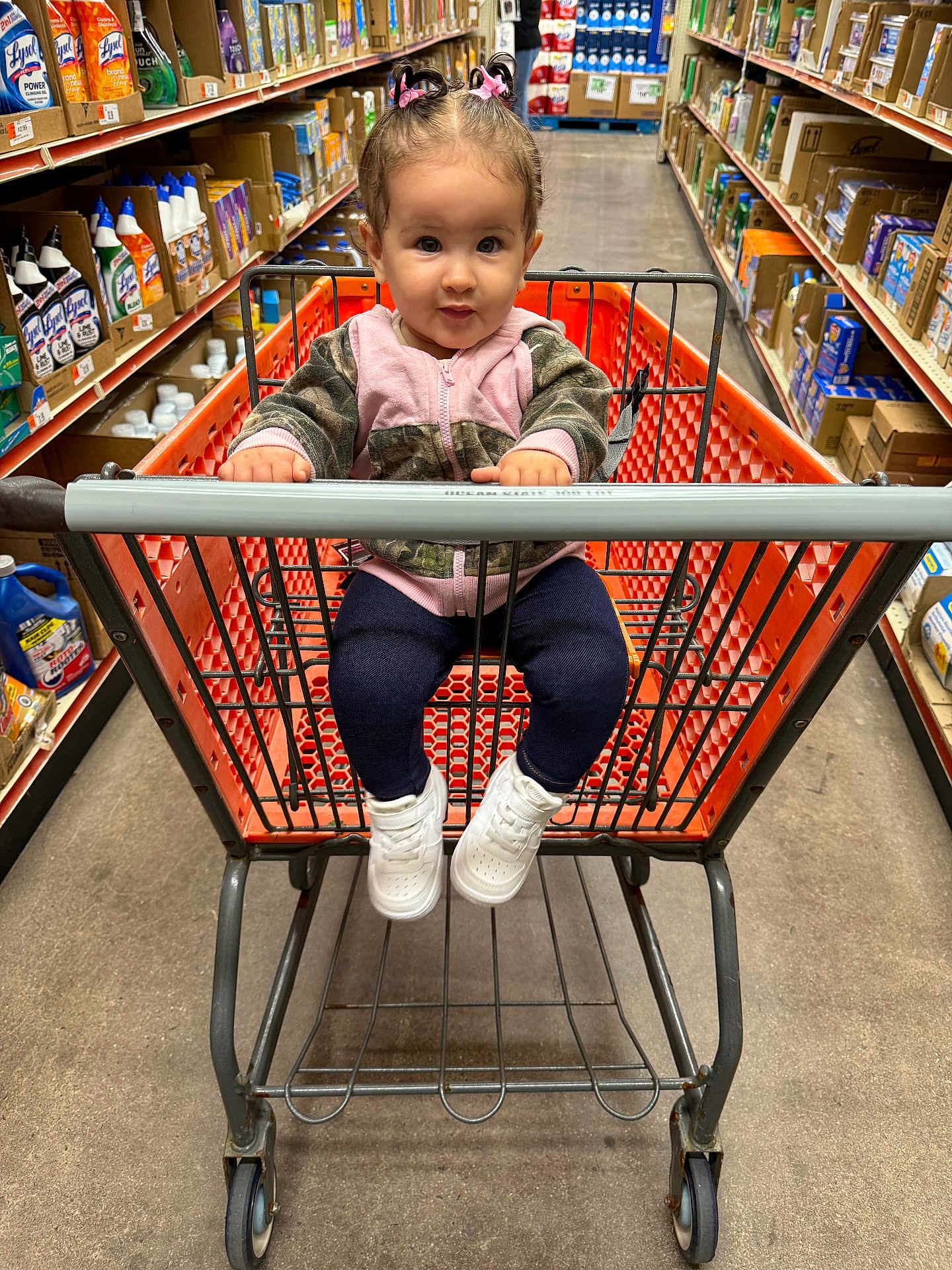 Elliana is registered to the contest to win money with this photo: toddler, child, shopping_cart, store_aisle, sneakers, jacket, hair_ties, curious, shopping, floor, shelf, products, cleaning_supplies, boxes, person, retail, indoor, grocery_store, baby, clothing