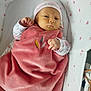 baby, infant, blanket, pink, hat, bassinet, heart_pattern, clothing, sleeping_bed, cute, newborn, soft_texture, child, indoors, resting, portrait, cozy, wrapped, young, peaceful