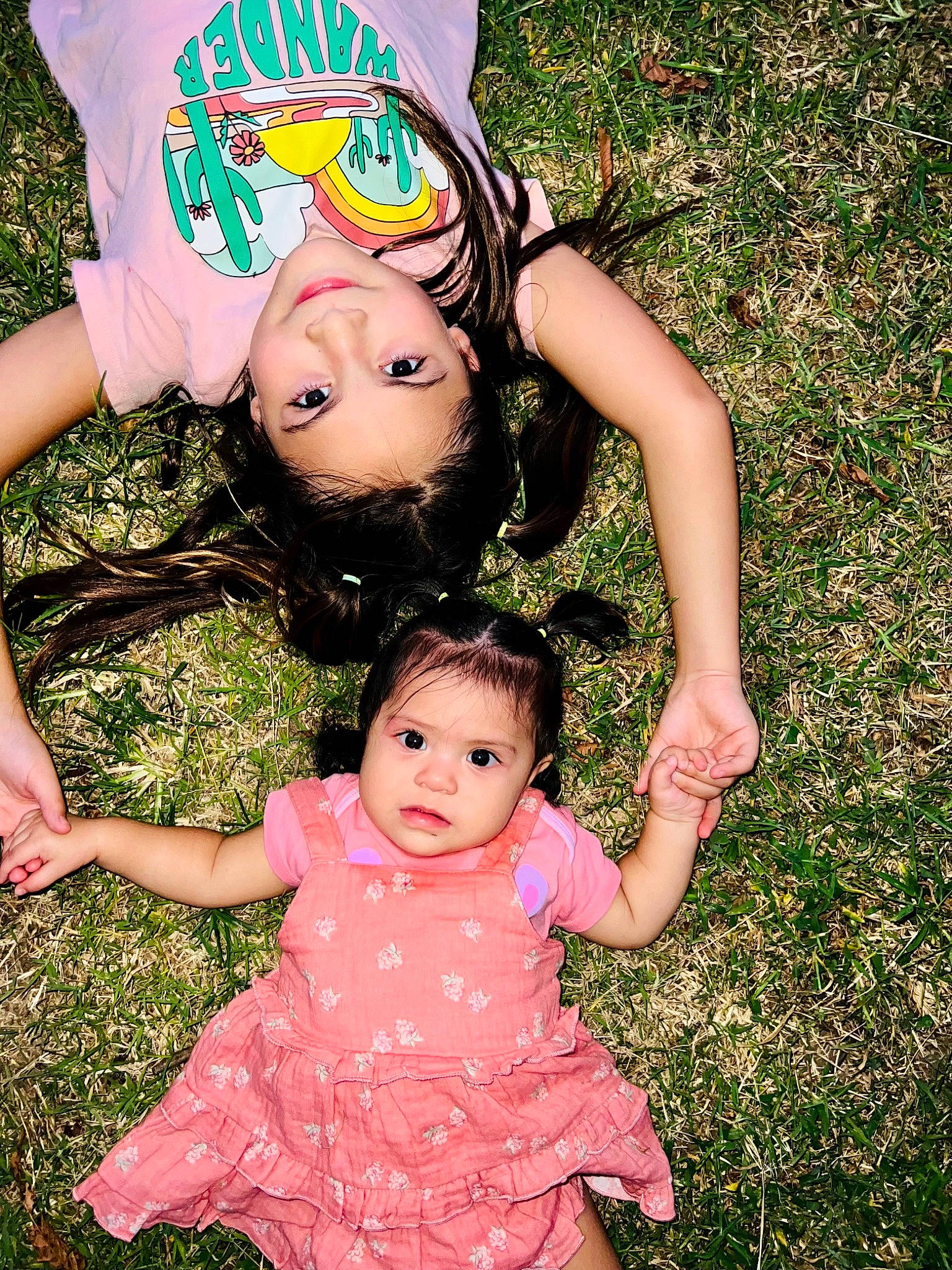 Arya is registered to the contest to win money with this photo: baby, baby_toddler_clothing, dress, eye, face, facial_expression, gesture, grass, green, hand, happy, human_body, joy, leaf, people_in_nature, person, photograph, pink, plant, skin