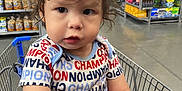 Carlos joined the competition — help win amazing prizes! toddler, child, shopping_cart, supermarket, curly_hair, clothing, shirt, grocery_store, aisle, hand, person, indoor, expression, young_child, face, retail, shopping, cute, casual_wear, baby