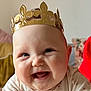 baby, child, clothing, crown, cute, expression, face, hands, happy, head, human, indoor, infant, long_sleeve, patterned_clothes, person, portrait, red_nail_polish, skin, smile