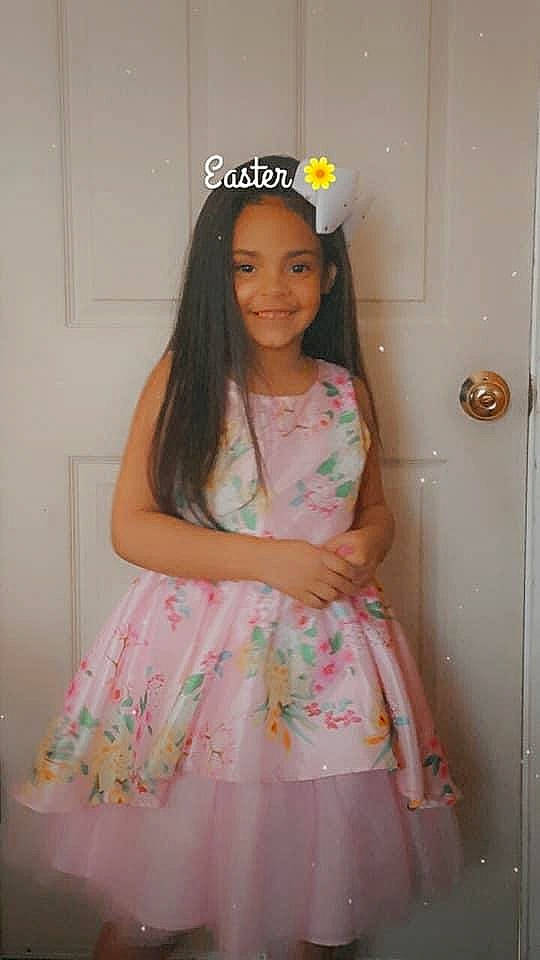 Arianna is registered to the contest to win money with this photo: day_dress, door, dress, embellishment, event, face, fashion_design, formal_wear, happy, head, jewellery, joy, long_hair, magenta, one_piece_garment, pattern, peach, person, pink, skin