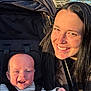 baby, woman, smiling, stroller, outdoor, daylight, child, person, happiness, black_hair, seatbelt, nature, face, portrait, infant, casual_clothing, sunlight, park, cheerful, closeup