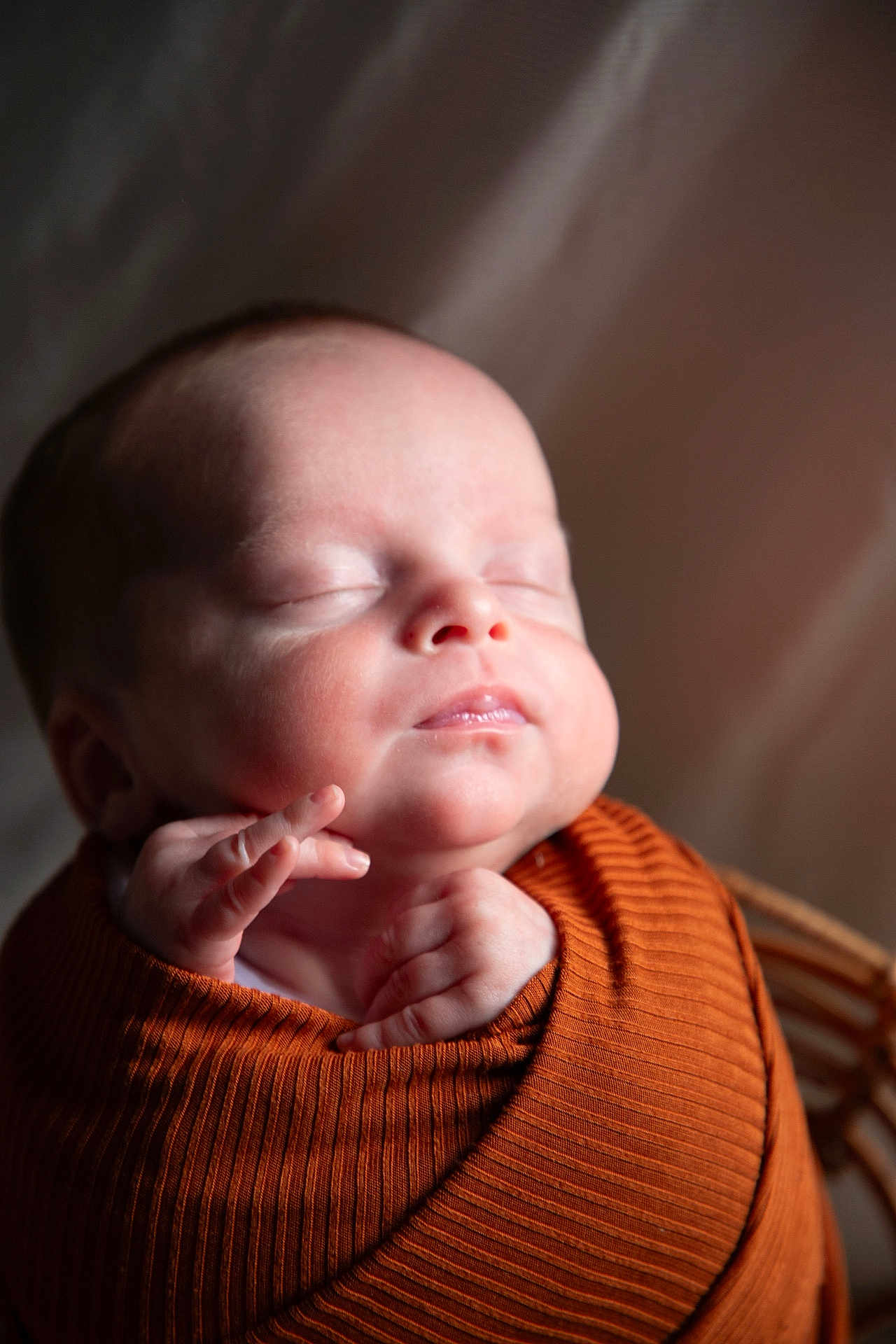 Bryson is registered to the contest to win money with this photo: baby, newborn, sleeping, wrapped, blanket, infant, face, skin, peaceful, portrait, soft_light, cozy, cute, child, closeup, resting, indoors, head, small_hands, warm_colors