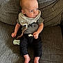 Bryson is registered to the contest to win money with this photo: baby, infant, pacifier, clothing, bib, couch, fabric, texture, person, foot, hand, sitting, indoor, cute, young_child, looking_away, relaxed, home, casual, comfortable