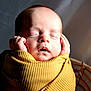Greyson is registered to the contest to win money with this photo: baby, sleeping, blanket, yellow, ribbed_texture, hands, face, peaceful, newborn, portrait, soft_light, closeup, cozy, infant, basket, wrapped, cute, skin, head, resting