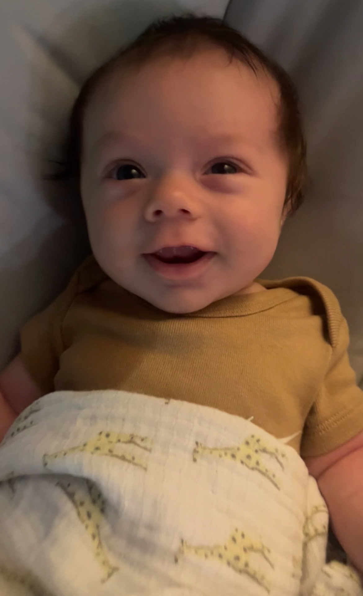 Shiloh is registered to the contest to win money with this photo: baby, infant, smile, face, blanket, giraffe_pattern, clothing, onesie, happy, cute, child, portrait, indoors, skin, head, cheeks, eyes, lying_down, person, cozy