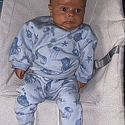 Reggie is registered to the contest to win money with this photo: baby, infant, child, baby_chair, clothing, blue_outfit, socks, face, hair, mohawk, sea_creatures, octopus, jellyfish, starfish, indoor, soft_fabric, baby_seat, cute, portrait, curious
