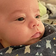 Swann a rejoint le concours — aidez-le/la à gagner de superbes lots ! baby, close_up, face, infant, blanket, pattern, bear_design, soft_lighting, skin, eyes, nose, mouth, cheeks, clothing, portrait, indoor, cute, newborn, sleepy, peaceful