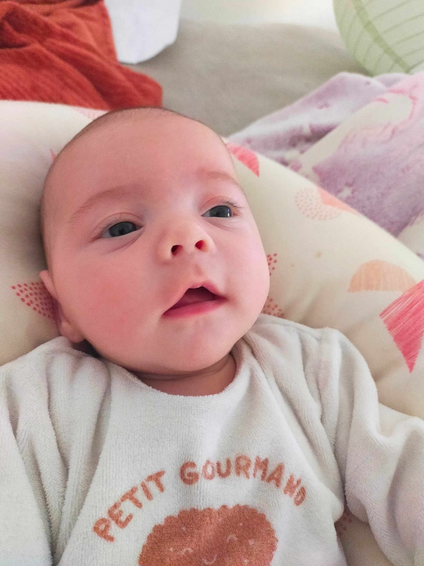 Swann participe au concours pour gagner de l'argent avec cette photo : baby, infant, face, eyes, mouth, clothing, white_outfit, cushion, blanket, indoor, closeup, person, child, cute, lying_down, soft_texture, expression, head, newborn, comfortable