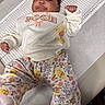 baby, child, clothing, cute, face, floral_pattern, footwear, hand, indoors, infant, lying_down, measurement_chart, pants, person, portrait, smile, soft_lighting, sweater, table, winnie_the_pooh