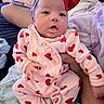 baby, infant, pink_clothing, red_hearts, headband, red_bow, hand, blanket, person, indoor, cute, sleepwear, cozy, soft, portrait, child, newborn, sitting, family, comfort